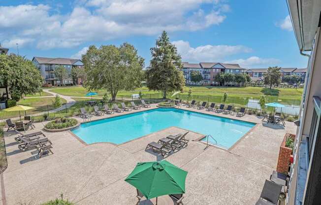 Aerial view of our pool with poolside lounge chairs and an umbrella table at Ultris Island Park in Shreveport, LA