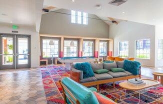 a living room with a pool table and couches