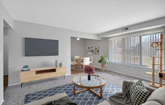 A living room with a flat screen TV mounted on the wall.