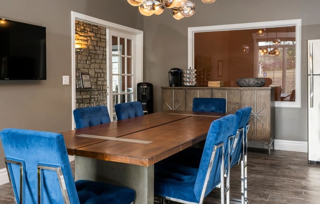 a dining room with a long wooden table and blue chairs