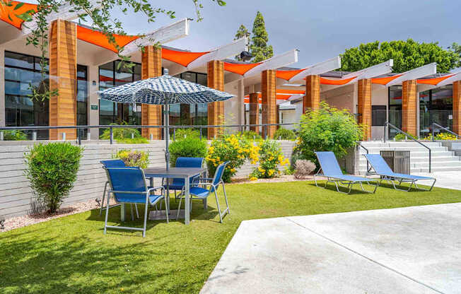A patio with a table and chairs is in front of a building.