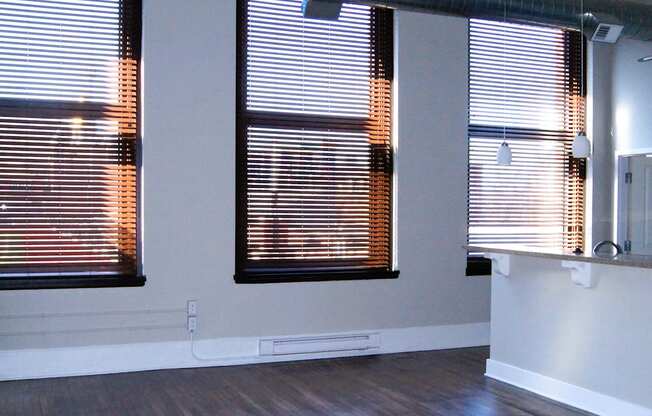 an empty living room with wood floors and windows at Residences at South High, Pittsburgh, PA ? 