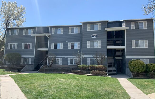 a grey apartment building with steps leading up to the front door