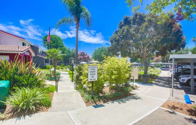 a sidewalk in front of a house with a sign on the sidewalk