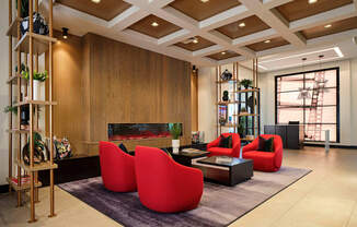 a living room with red chairs and a fireplace