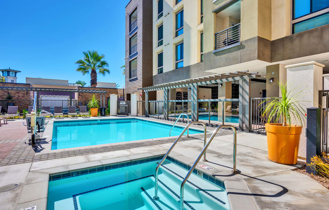A swimming pool with a diving board in front of a building.
