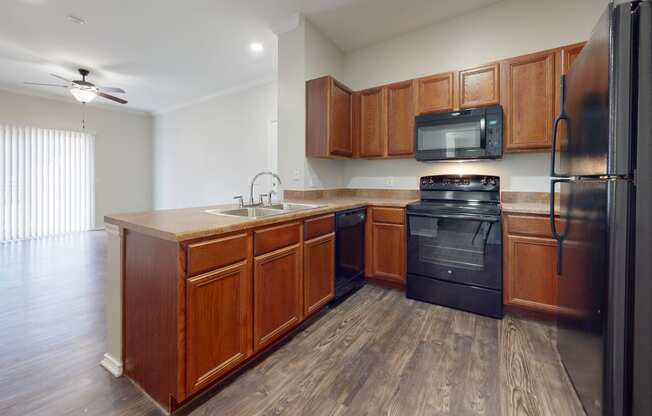 Spacious kitchen with hardwood style flooring and black appliances