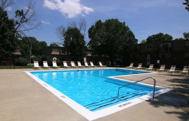 A swimming pool with a white line on the edge and a metal railing.