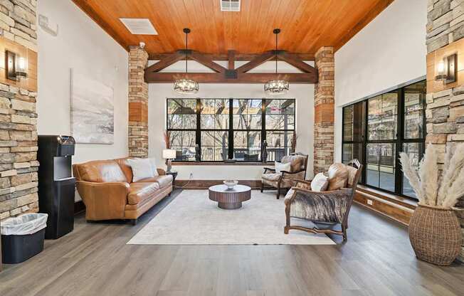 A living room with a brown leather couch and a wooden floor.