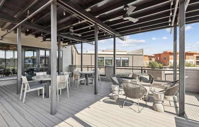 A patio with a table and chairs is covered by a roof.