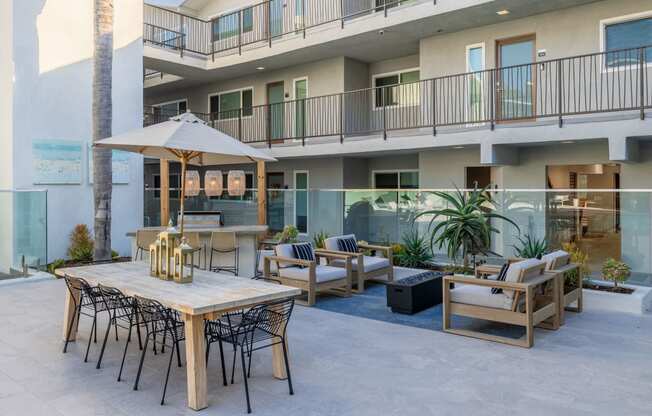 an outdoor patio with tables and chairs and a building in the background