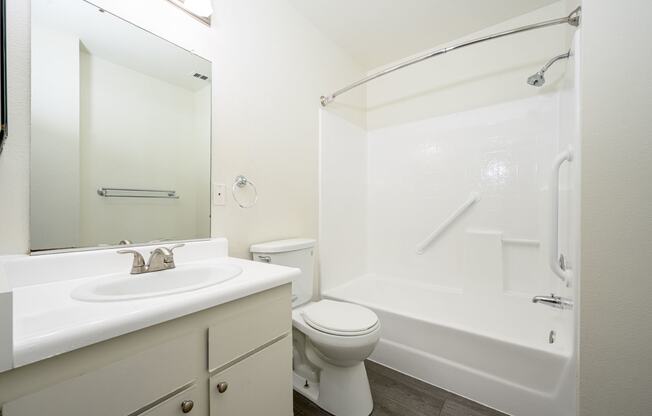 a bathroom with a bathtub toilet sink and mirror at Sagewood Gardens Senior Apartments, Hacienda Heights, CA