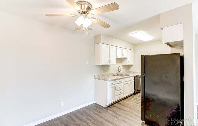 a kitchen with white cabinets and a stainless steel refrigerator