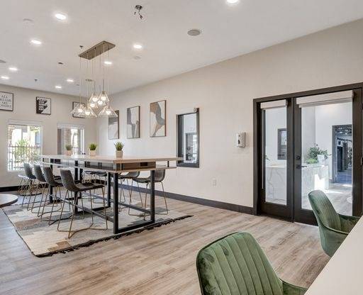 A modern dining room with a long table and chairs.
