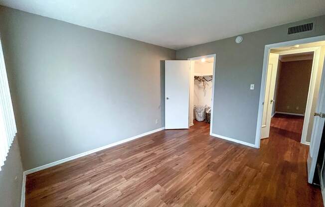 A room with wooden flooring and a white door.