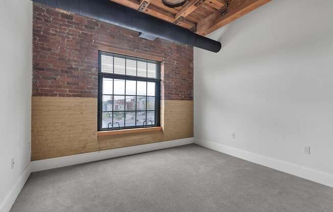 A room with a brick wall and a window.