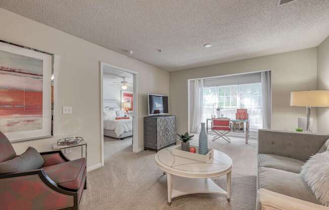A living room with a red couch and a white coffee table.