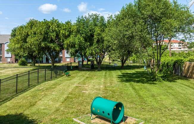 a green park with trees and a green pipe