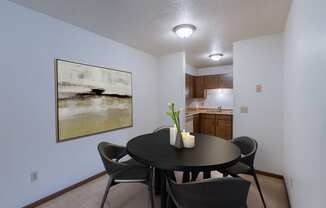 a dining room with a table and chairs and a kitchen. Moorhead, MN South Park Apartments