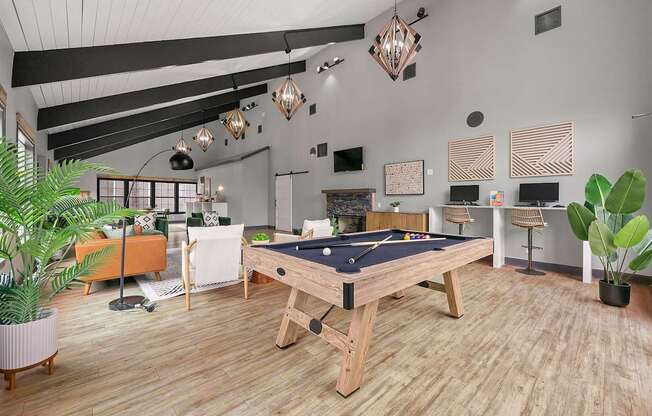 A pool table is in the middle of a room with a wooden floor.