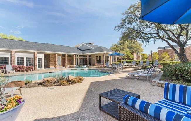 A poolside patio with a blue and white striped couch.