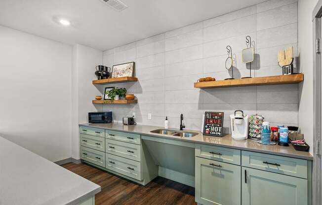 A kitchen with green cabinets and a white countertop.