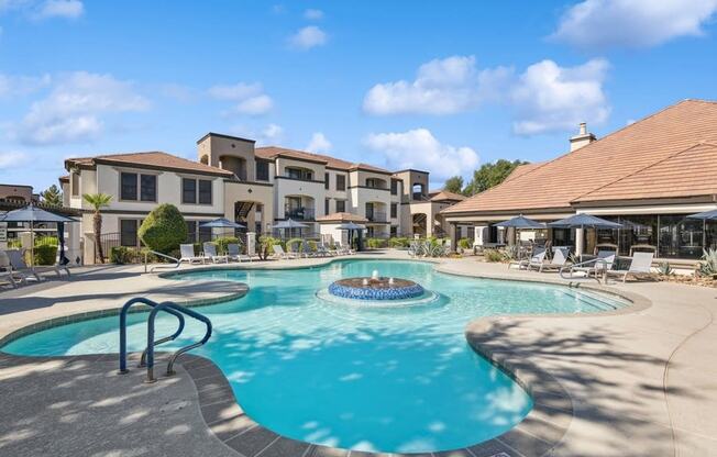 a swimming pool with a fountain in front of a building