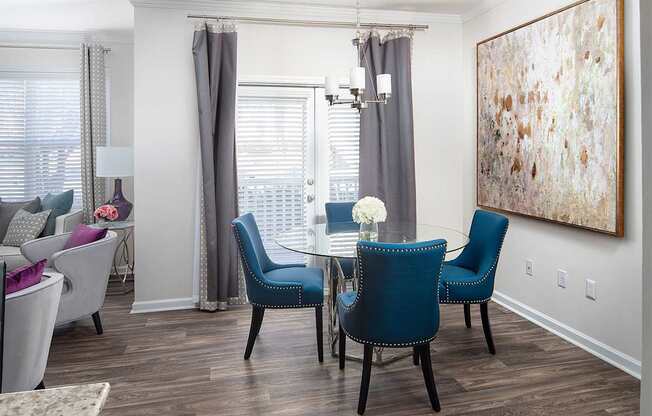 A dining room with a table and blue chairs.