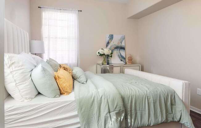 a bedroom with a bed with blue and yellow pillows