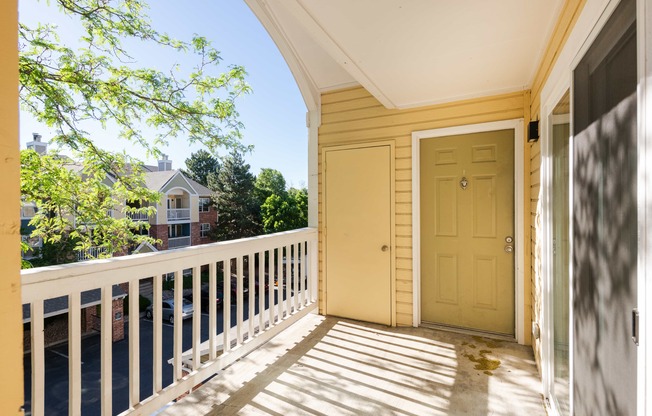 the front porch of a yellow house with a yellow door