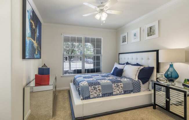 staged bedroom with carpeted flooring, window, and ceiling fan