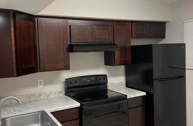 a kitchen with black appliances and granite counter tops