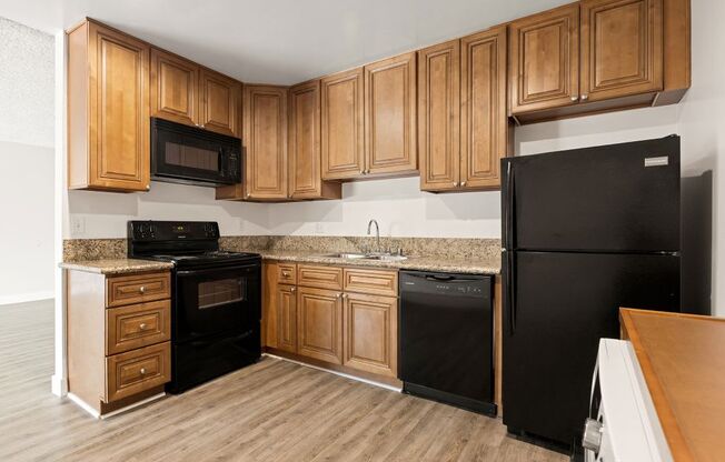 a kitchen with black appliances and wooden cabinets