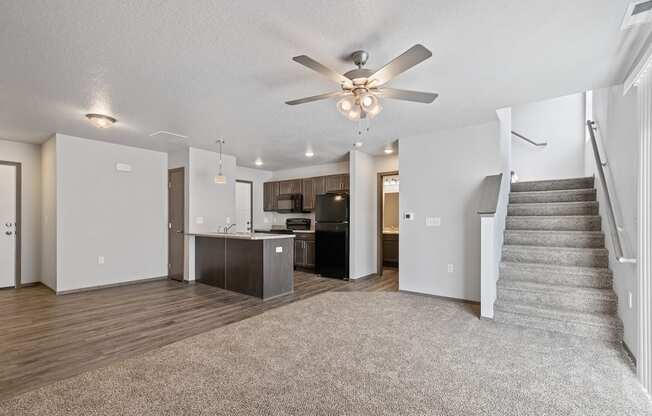 Modern open-concept kitchen and living area with black appliances.