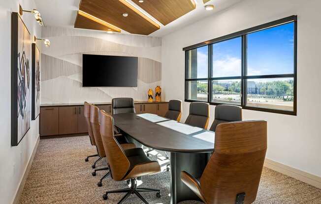 A conference room with a long table and chairs.