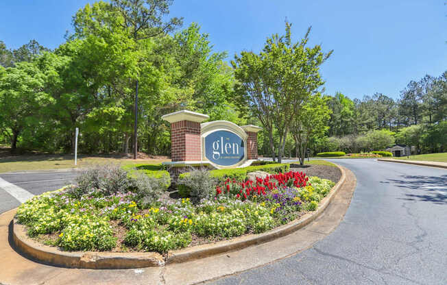 A sign that says Glen stands in front of a flowerbed.