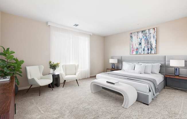 A bedroom with a large bed, two chairs, and a painting on the wall at Metro 303, Hempstead, NY, 11550