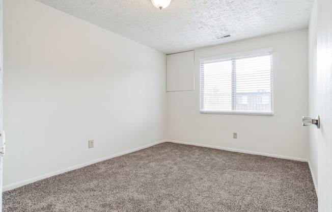 an empty room with carpet and a window