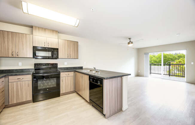 A kitchen with wooden cabinets and black appliances.