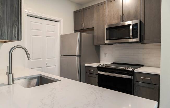 a kitchen with stainless steel appliances and a white counter top