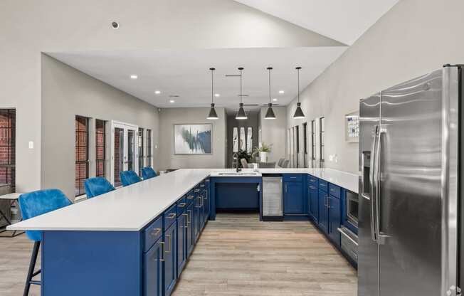 a large kitchen with blue cabinets and white countertops