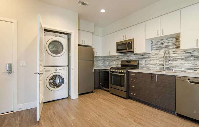 A modern kitchen with a washer and dryer built into the cabinetry.