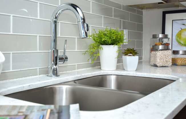 a stainless steel kitchen sink with a chrome faucet at Apartments at Denver Place, Colorado, 80202