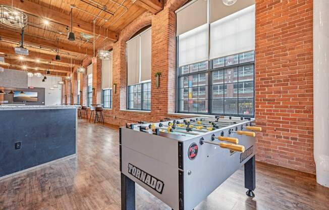 a foosball table in a room with brick walls and a bar