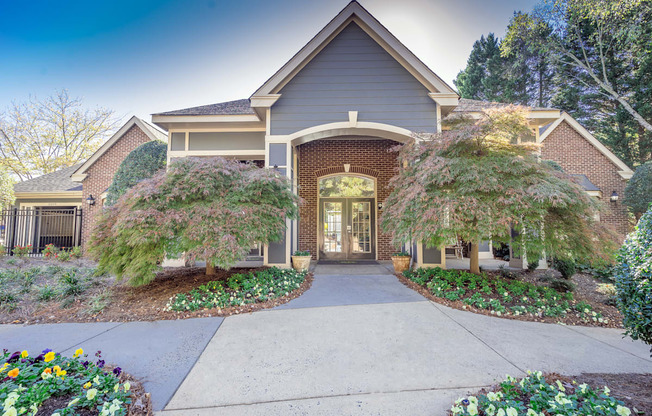 the front of the clubhouse with a walkway and two trees at Radbourne Lake Apartments, North Carolina, 28269