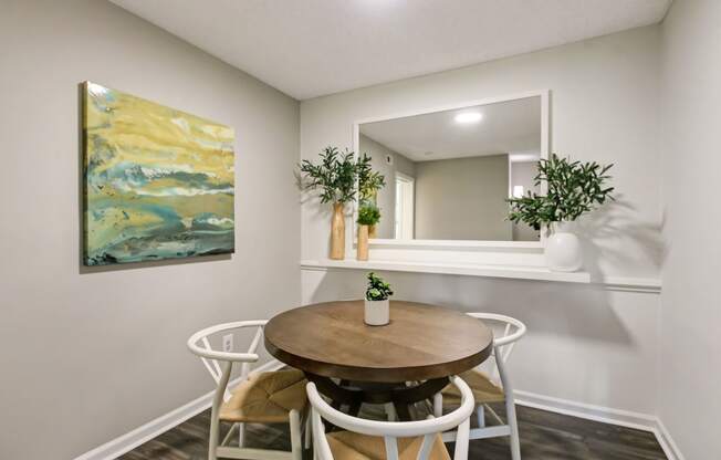 a dining room with a table and chairs and a mirror