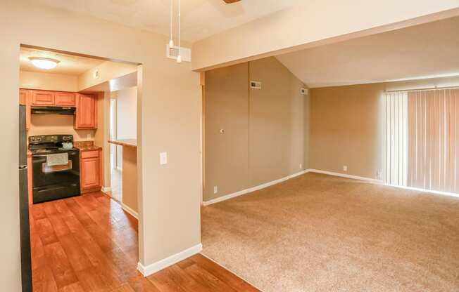 an empty living room and kitchen with wood flooring. Omaha, NE Evergreen Terrace Apartments