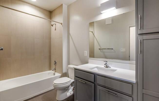 a bathroom with a sink toilet and tub and a mirror