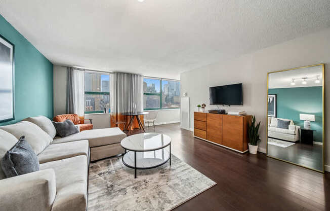 A living room with a white sofa, a coffee table, and a television.