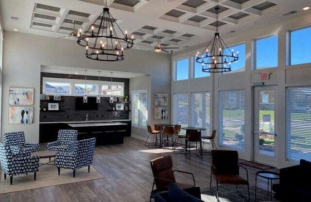 a lobby with chairs and a bar and chandeliers